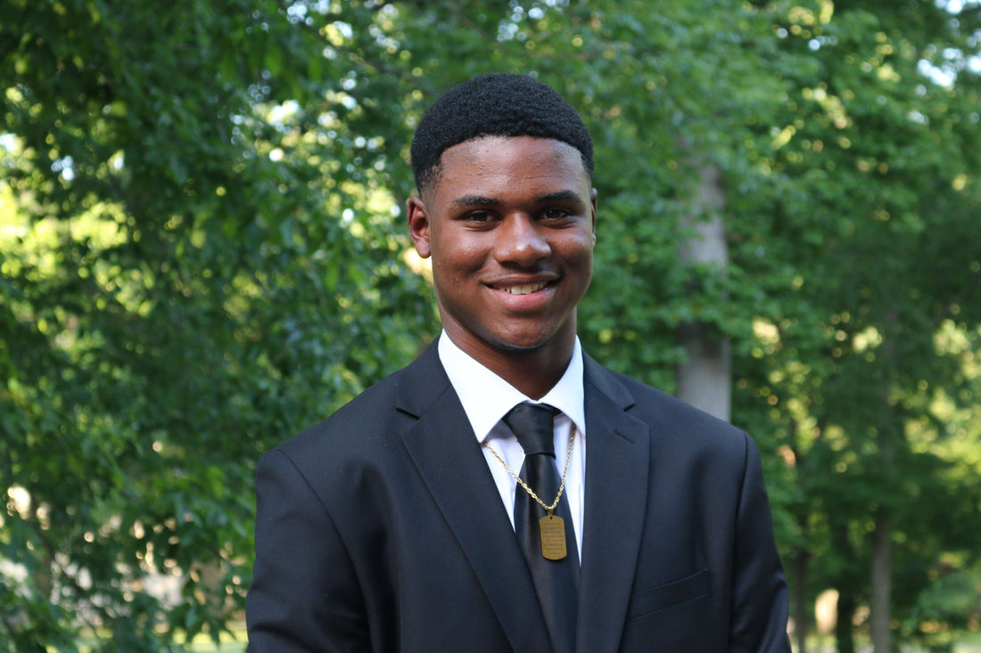 Roland Ivy smiling in a suit and tie outdoors, representing a Criminal Justice student and volunteer.