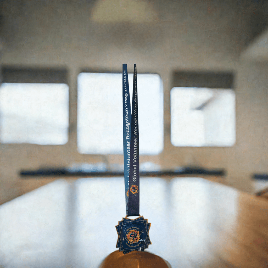 2025 Global Volunteer Recognition Program Membership Keepsake Medal with a blue ribbon in a room