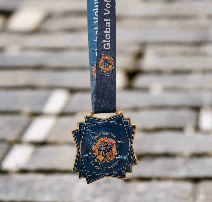 2025 Global Volunteer Recognition Program Membership Keepsake Medal with a blue ribbon on a street