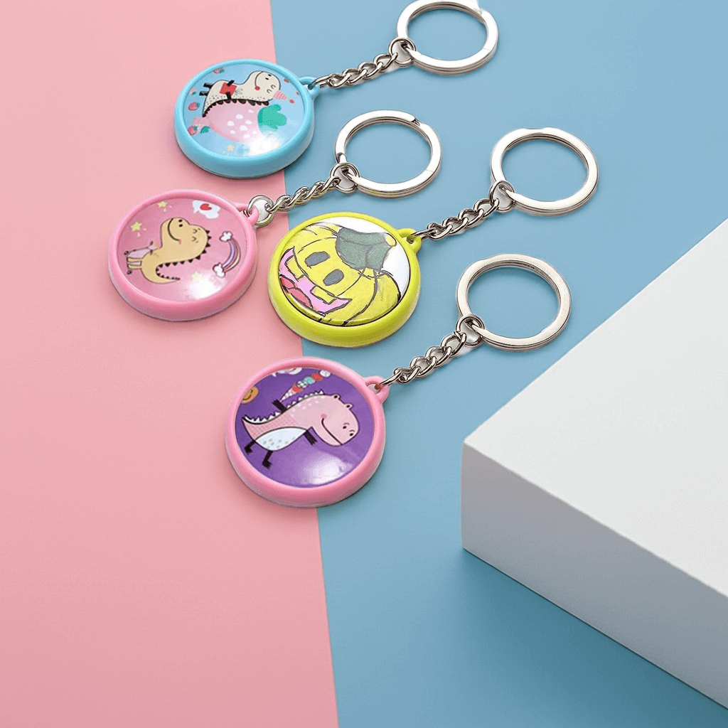 Personalized Four colorful custom keychains with unique designs on a blue and pink background, showcasing personalized artwork.