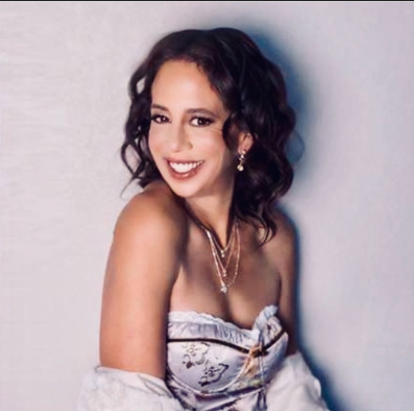 Woman wearing a strapless dress with floral details against a plain background