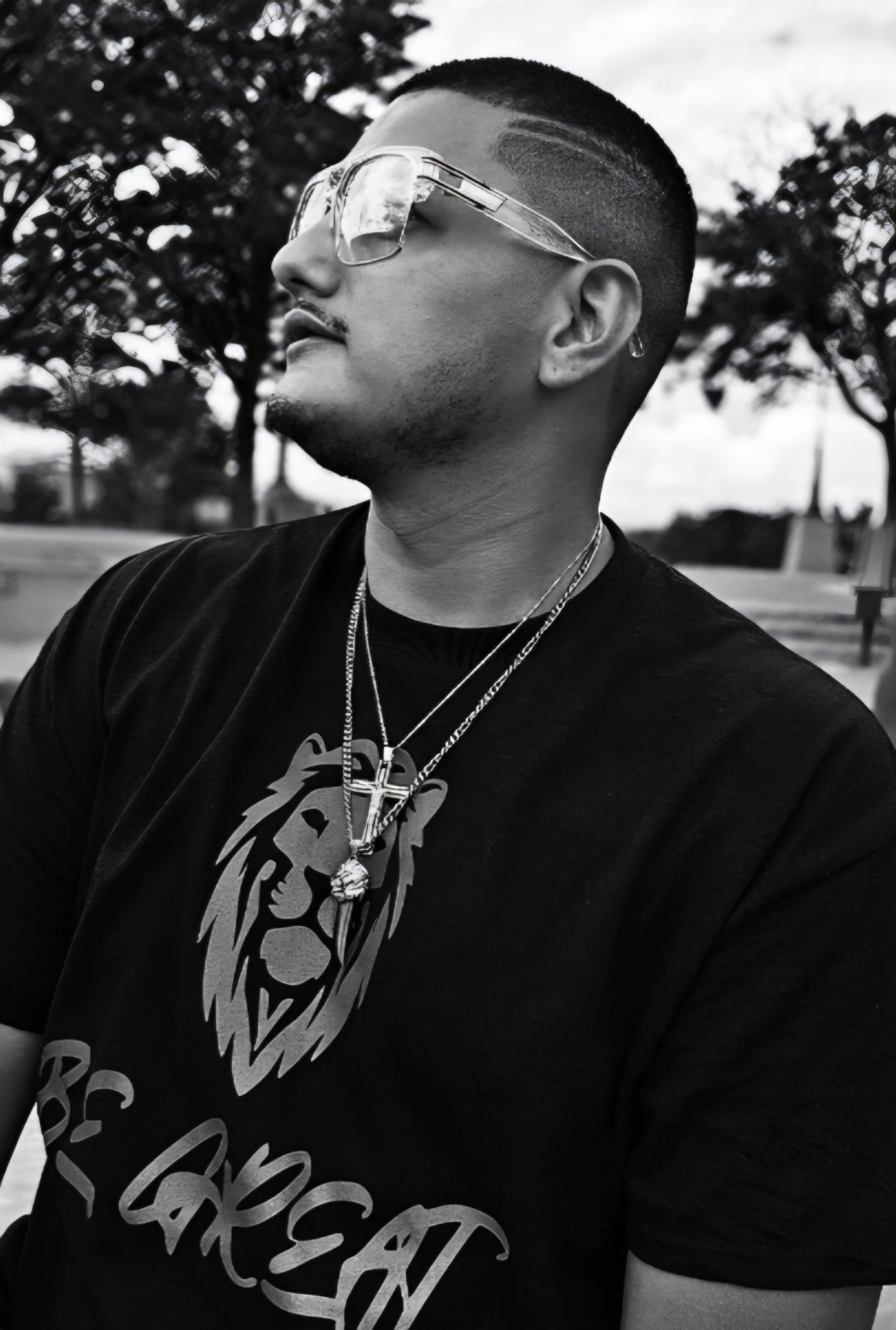 Person wearing a black t-shirt with a lion graphic and text, standing outdoors.