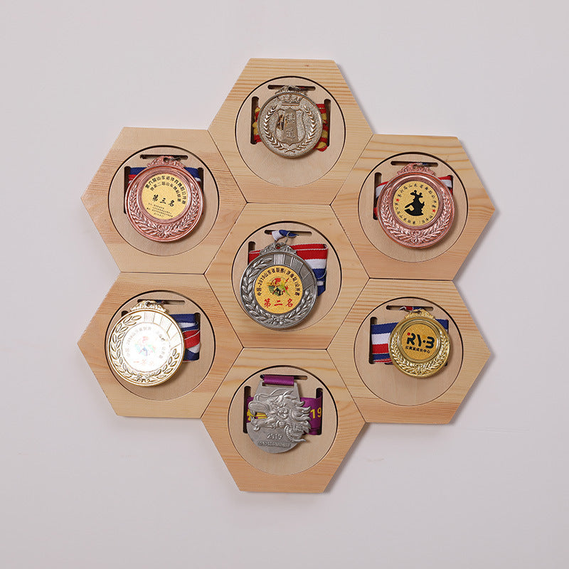 Hexagonal wooden display with various medals on a white background