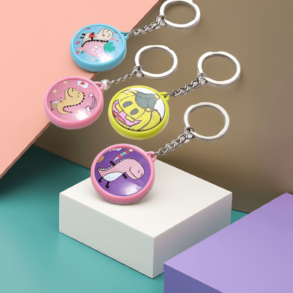 Personalized Four colorful 1 inch custom keychains featuring fun cartoon designs on a modern geometric background.