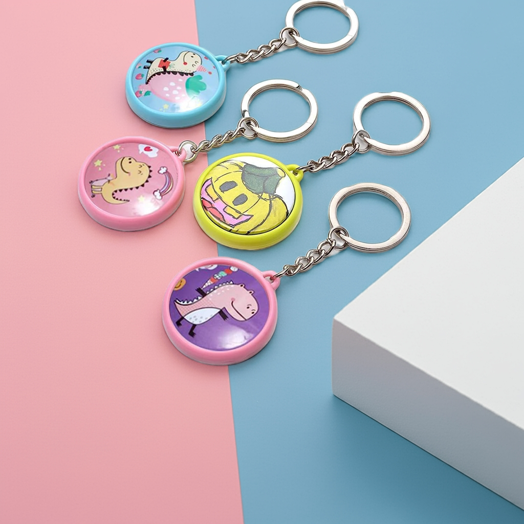 Four colorful custom keychains with unique designs on a blue and pink background, showcasing personalized artwork.