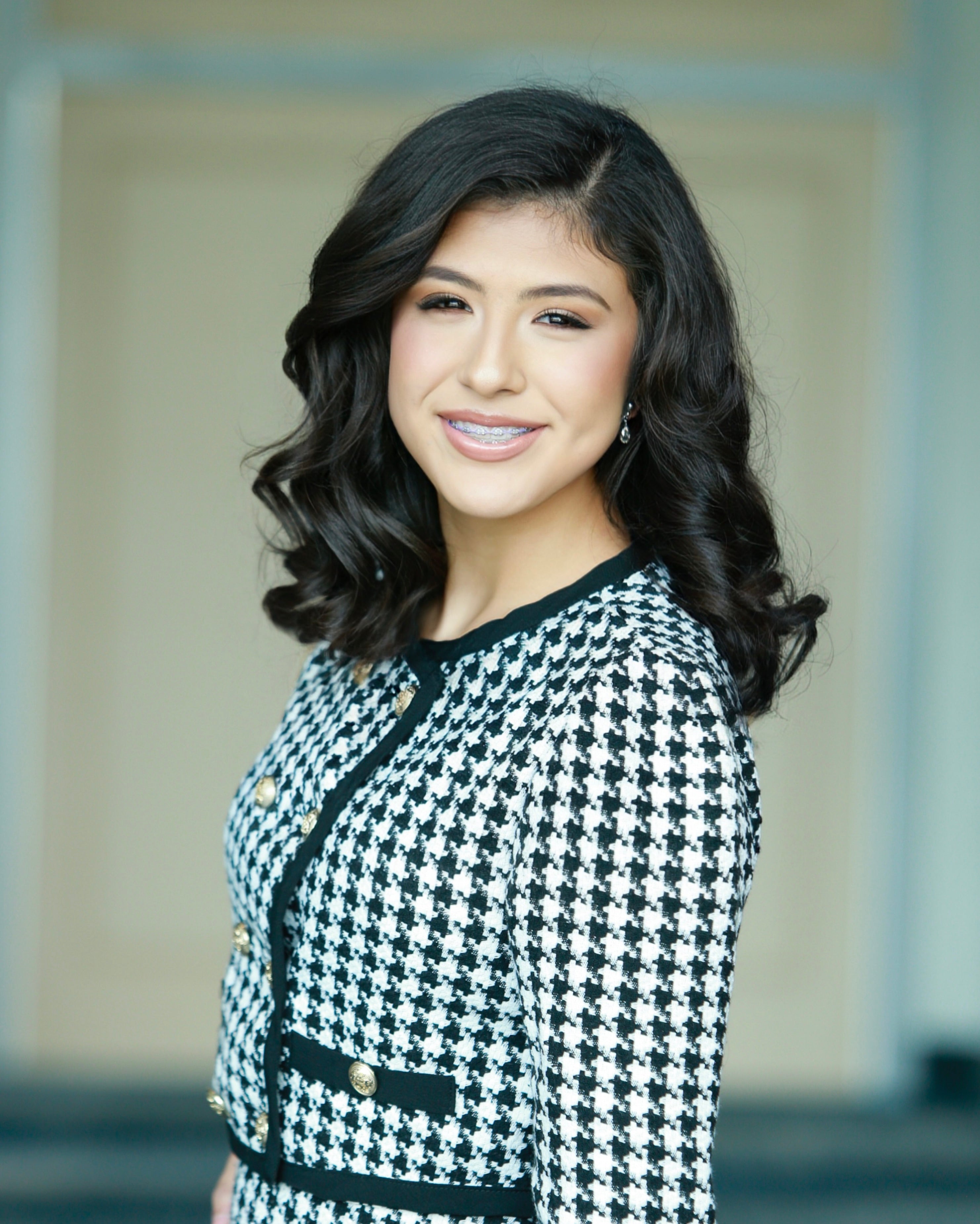 Woman wearing a black and white checkered outfit with a blurred background