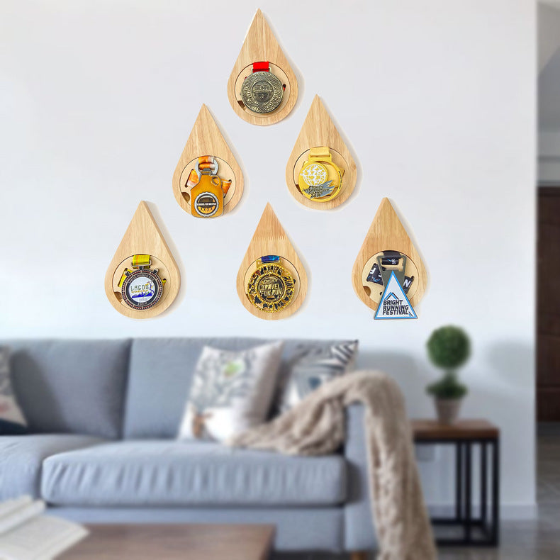 Set of wooden teardrop shaped medal displays with various designs on a white background