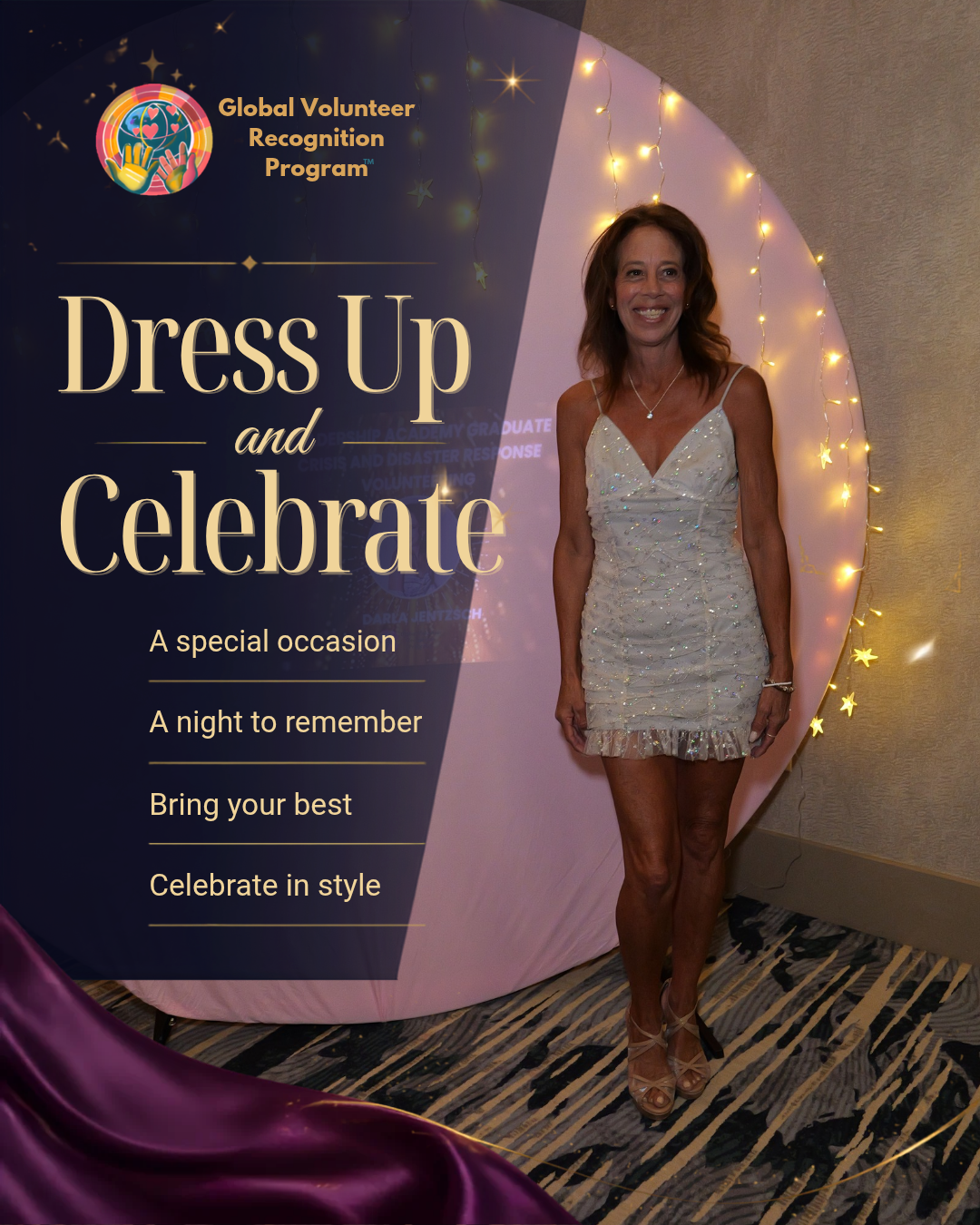 A woman stands in front of a decorative event backdrop that reads 'Global Volunteer Recognition Program' and 'Dress Up and Celebrate,' wearing a short white embellished dress and tan heels.