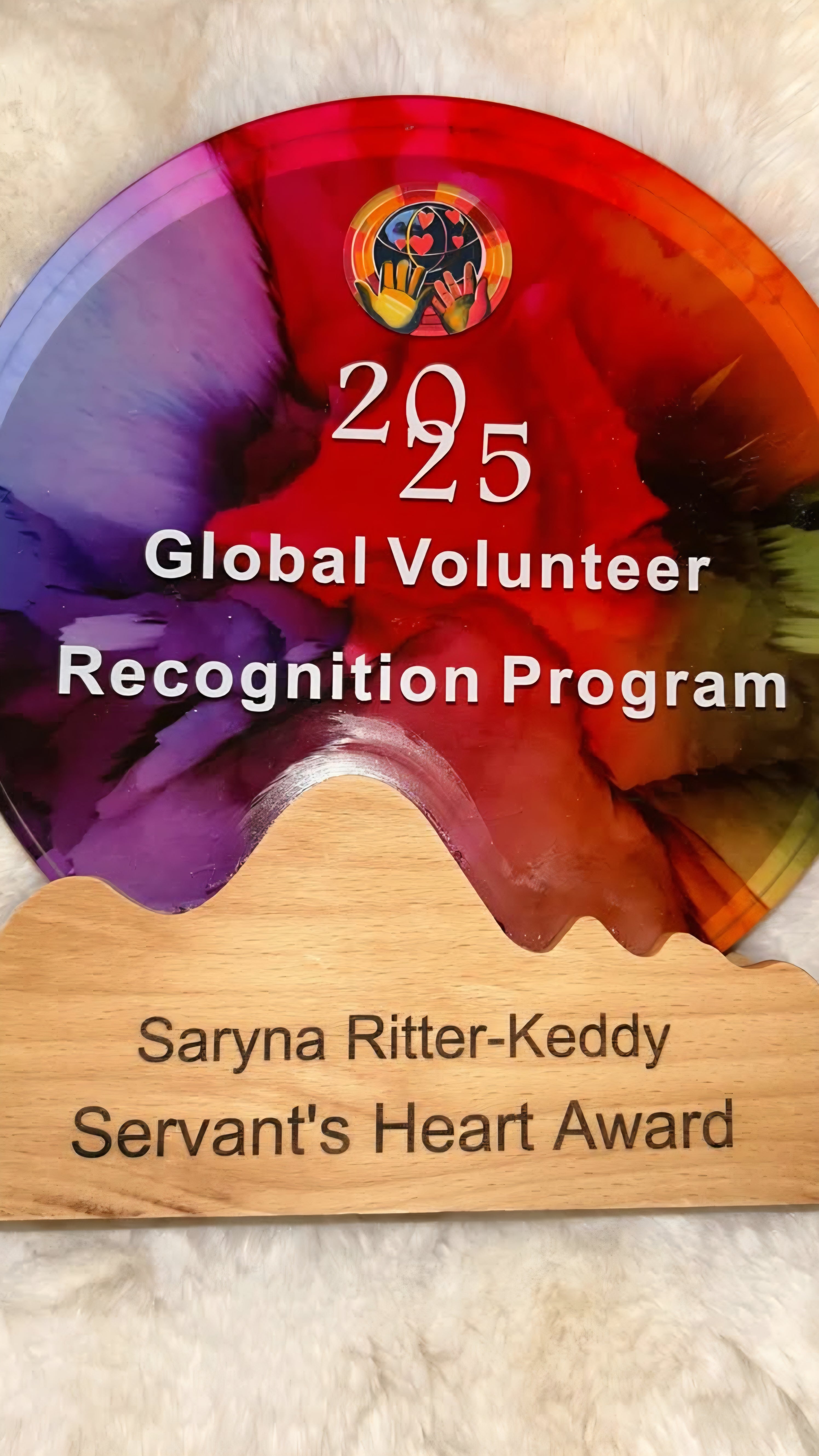 Award plaque for the 2025 Global Volunteer Recognition Program with a colorful design and engraved text.