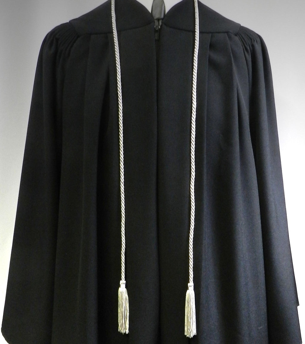 Black academic gown with white tassels on a gray background