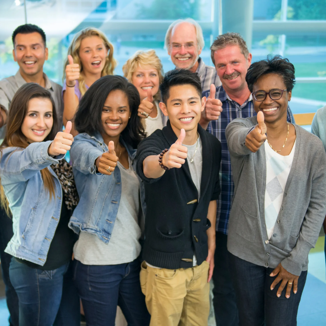 Group of people giving thumbs up in a bright indoor setting